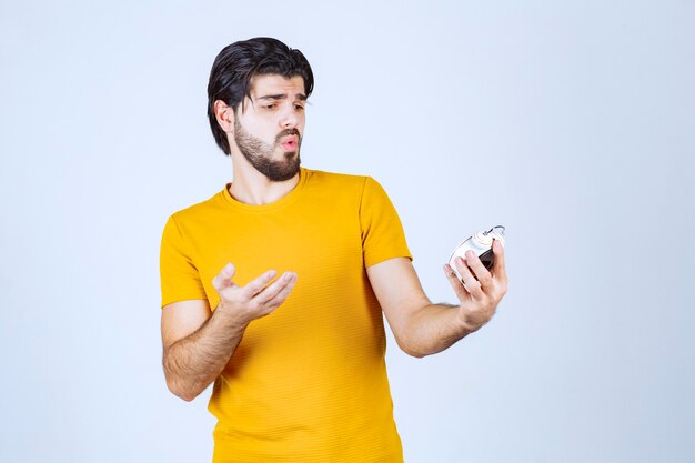 Homme regardant un réveil et pensant.