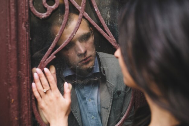 Homme regardant sa petite amie à travers un verre