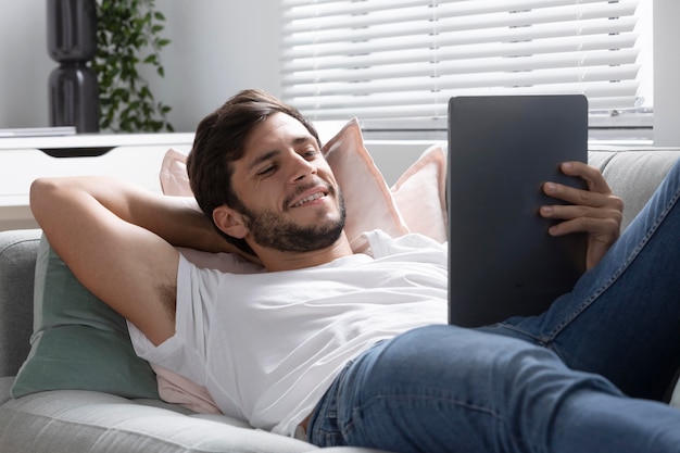 Photo gratuite homme regardant son film préféré sur une tablette