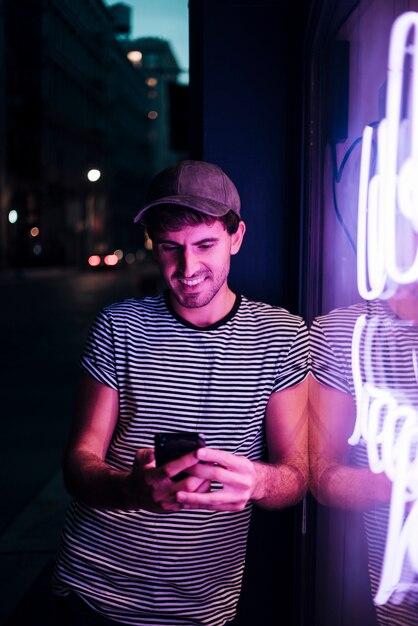 Homme regardant son téléphone et souriant