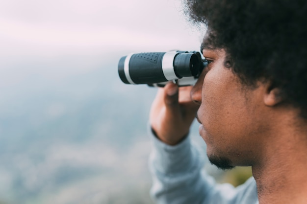 Homme regardant à travers des jumelles