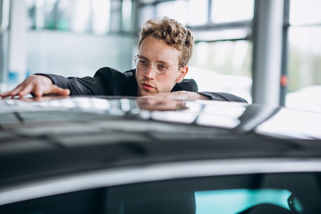 Photo gratuite homme regardant une voiture et songeant à un achat