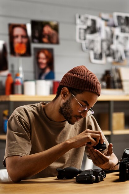 Homme réparant un appareil photo photo moyen