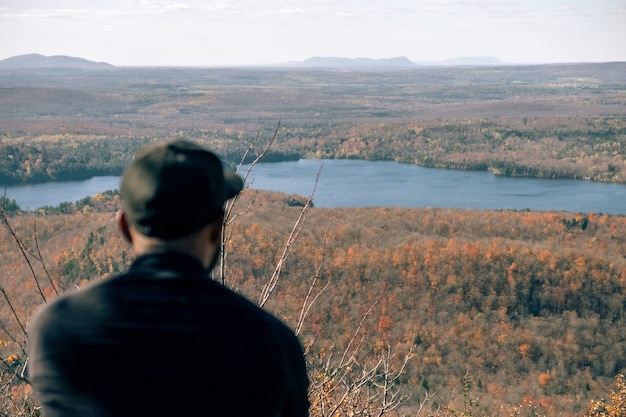 Homme reposant sur une montagne avec une belle vue sur la rivière et les plaines