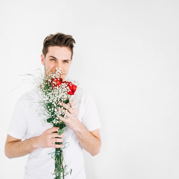 Homme romantique posant avec bouquet