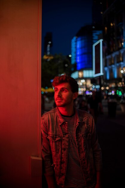 Homme s'appuyant sur un mur et regardant au loin