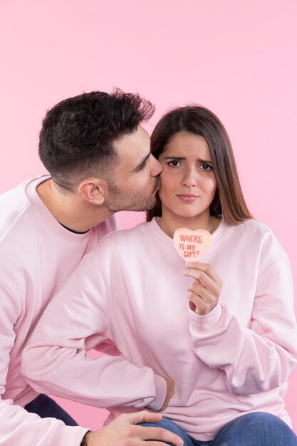 Homme s&#39;embrasser grave jeune femme avec coeur de papier