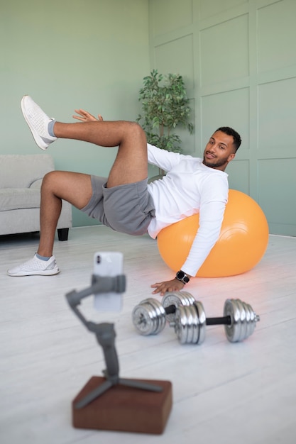 Photo gratuite homme s'entraînant avec un ballon de gym plein coup