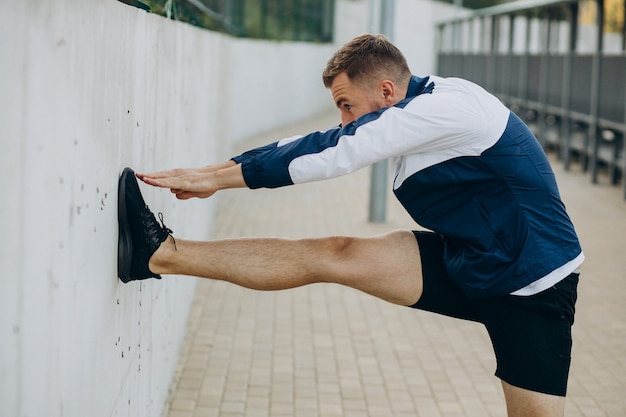 Homme s'étirant avant l'entraînement au stade