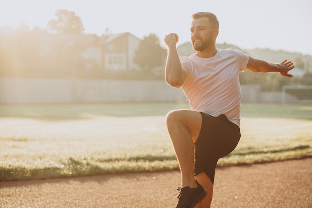 Homme s'étirant avant l'entraînement au stade