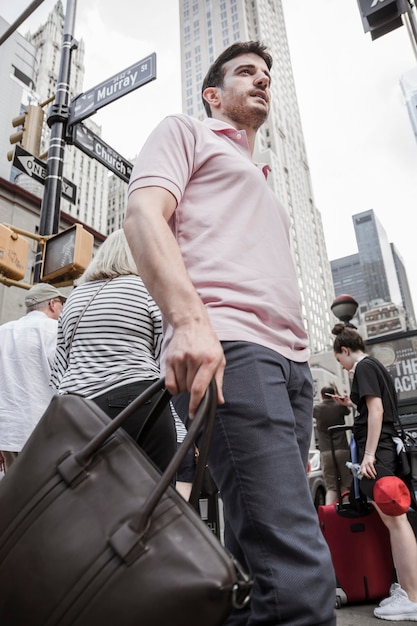 Homme, sac, debout, rue occupée