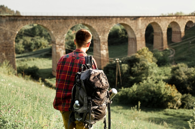 Photo gratuite homme avec sac à dos dans le champ vert