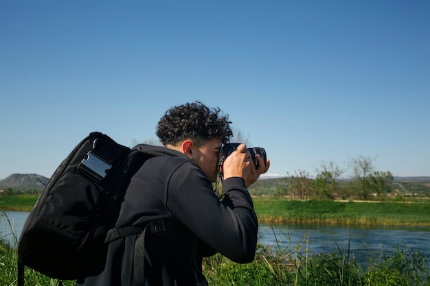 Homme avec sac à dos, prenant une photo de l&#39;eau qui coule