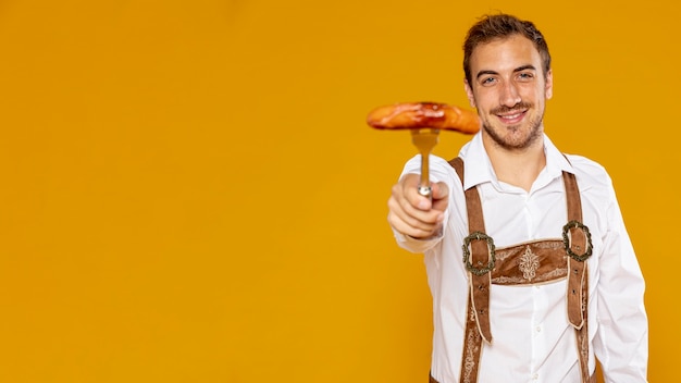 Photo gratuite homme avec saucisse allemande et espace de copie
