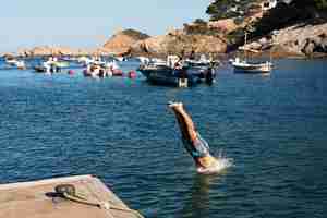 Photo gratuite homme sautant dans l'eau se bouchent