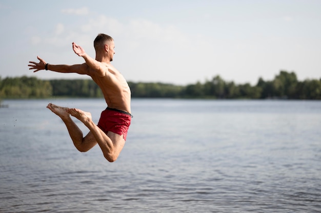 Photo gratuite homme sautant dans le lac