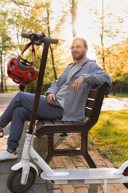 Homme avec scooter assis sur un banc