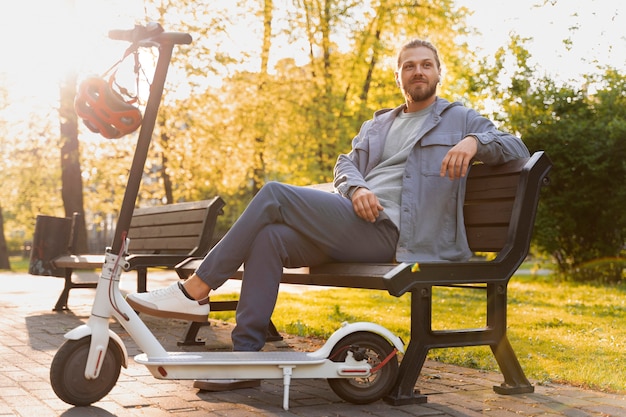 Homme avec scooter assis sur un banc