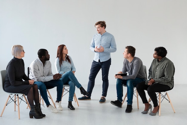 Homme se confessant devant d'autres patients