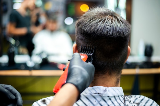 Homme se coupe les cheveux avec reflet de miroir flou