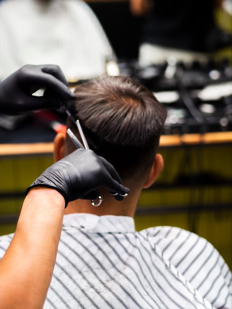 Homme se faisant couper les cheveux par derrière