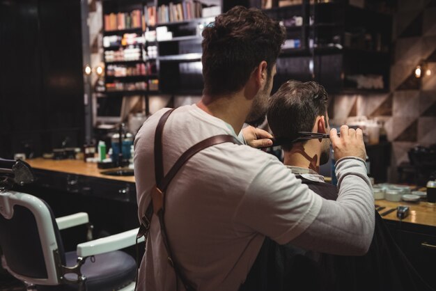 L'homme se fait couper les cheveux avec des ciseaux