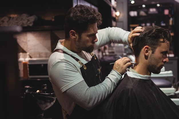 L'homme se fait couper les cheveux avec un rasoir