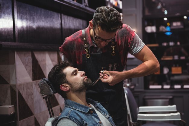 L'homme se fait tailler la barbe avec des ciseaux