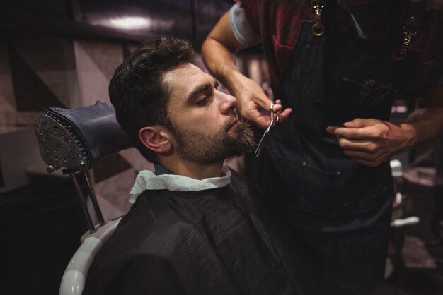 L'homme se fait tailler la barbe avec des ciseaux