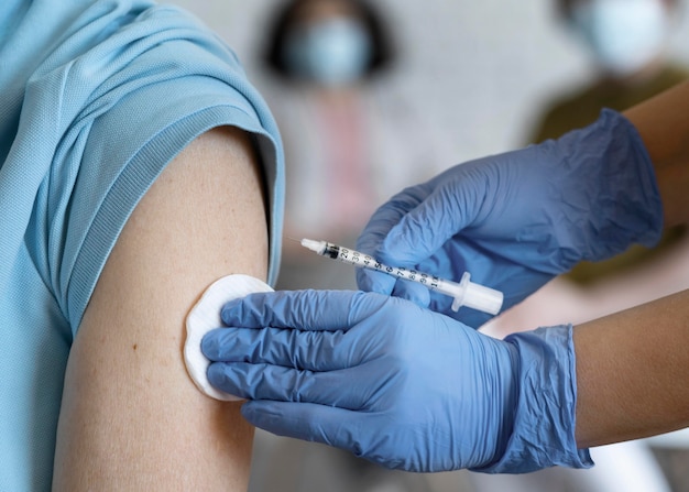 Un homme se fait vacciner par un médecin