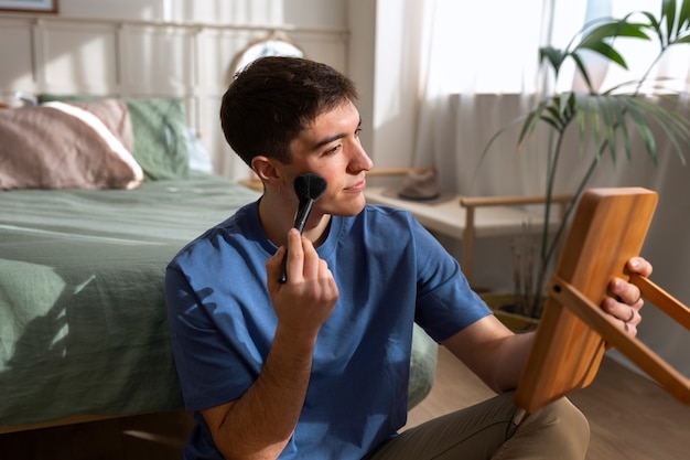 Photo gratuite homme se maquillant à l'intérieur