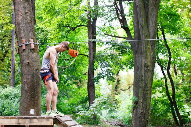 L&#39;homme se prépare à grimper sur les cordes dans le parc