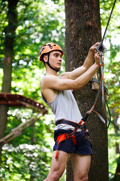 L&#39;homme se prépare à grimper sur les cordes dans le parc