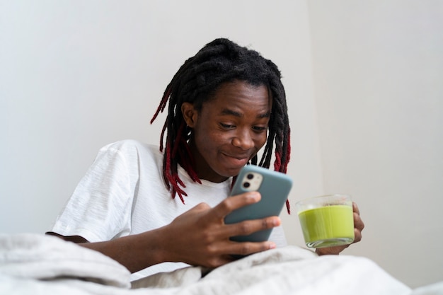 Photo gratuite homme se relaxant à la maison et dégustant une tasse de thé matcha