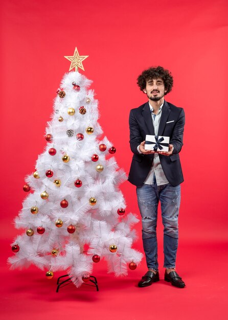 Un homme se tient à côté du sapin de Noël