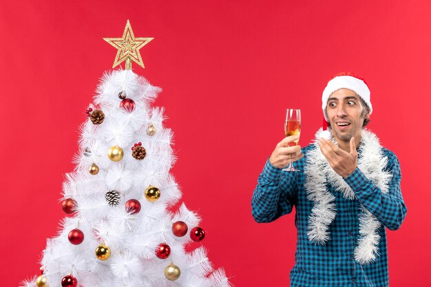 Un homme se tient à côté du sapin de Noël