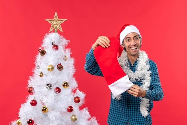 Un homme se tient à côté du sapin de Noël