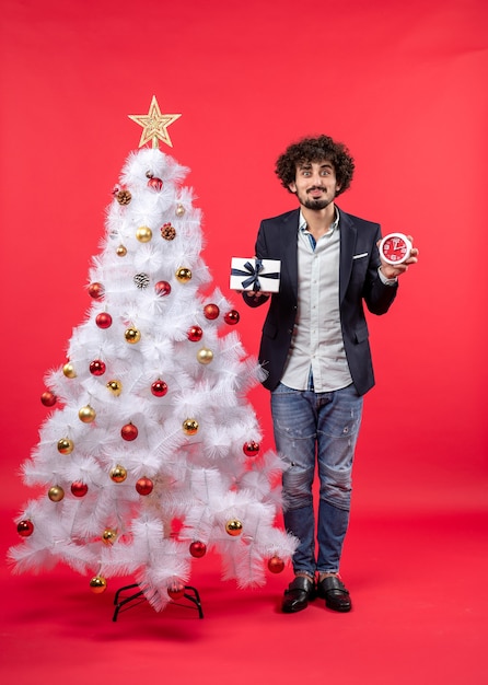 Un homme se tient à côté du sapin de Noël