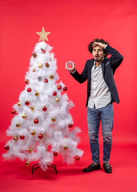 Un homme se tient à côté du sapin de Noël