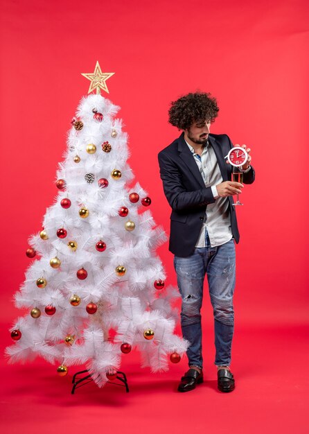 Un homme se tient à côté du sapin de Noël