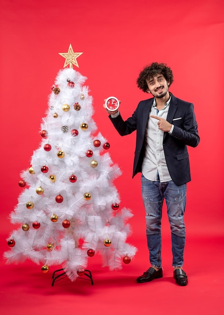 Un homme se tient à côté du sapin de Noël