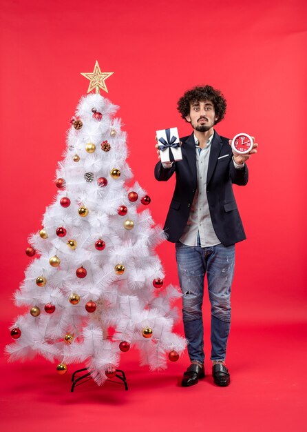 Un homme se tient à côté du sapin de Noël