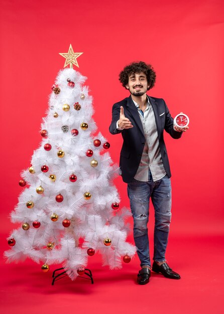 Un homme se tient à côté du sapin de Noël