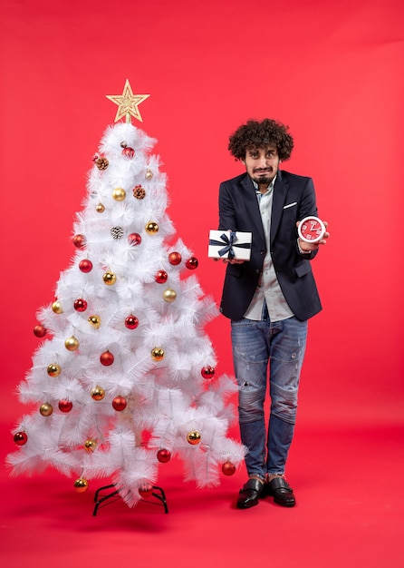 Un homme se tient à côté du sapin de Noël