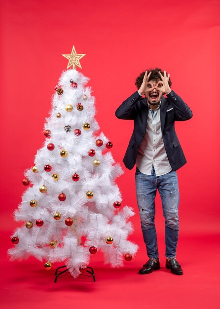 Un homme se tient à côté du sapin de Noël