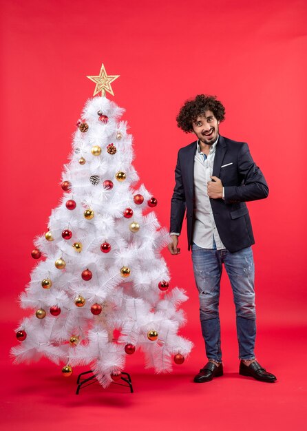 Un homme se tient à côté du sapin de Noël