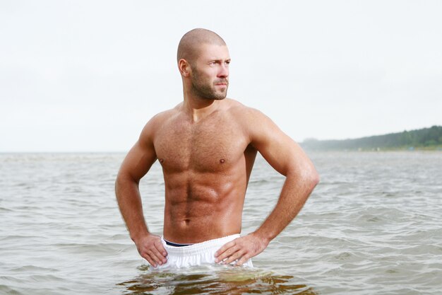 Homme séduisant et heureux sur la plage