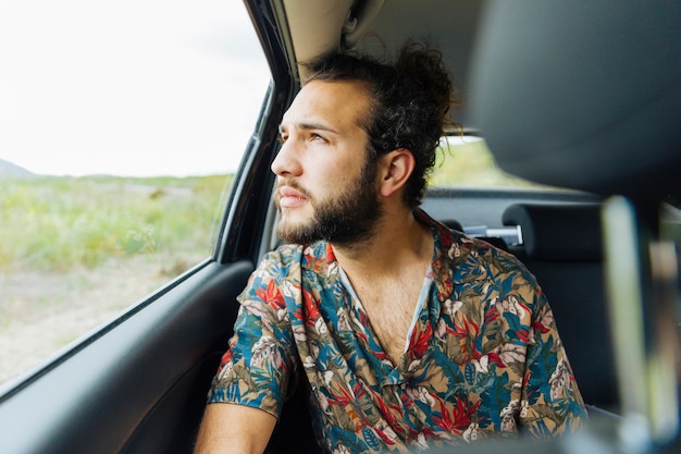 Homme séduisant, regardant la fenêtre de la voiture