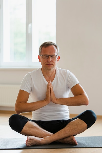 Homme senior concentré faisant du yoga