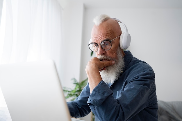 Homme senior de coup moyen portant des écouteurs